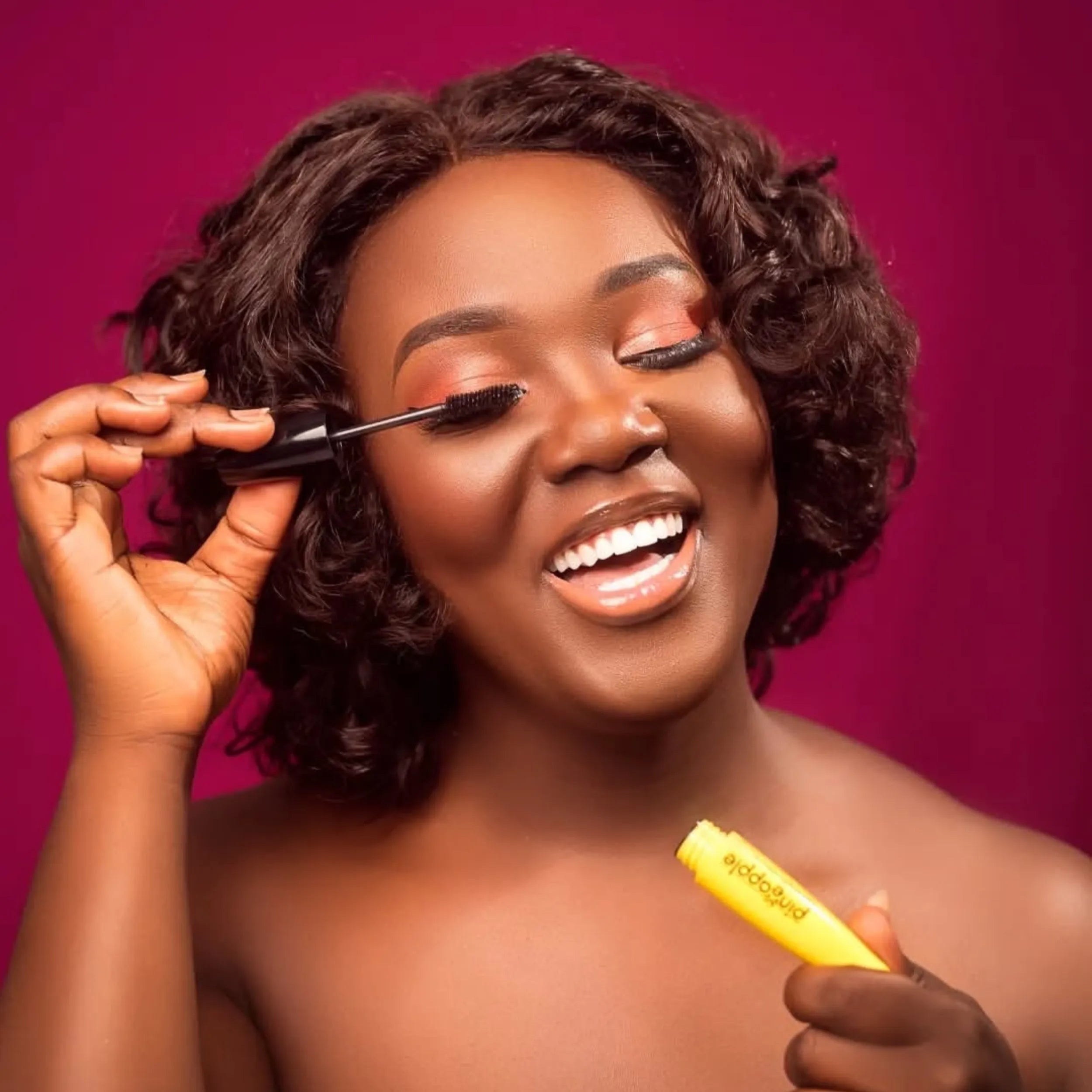 Woman applying mascara red background